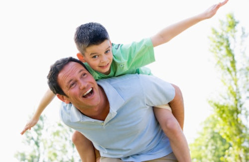 Man giving young boy piggyback ride outdoors,all pro dad thomas nelson book