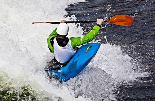 an active male kayaker rolling and surfing in rough water,an active male kayaker rolling and surfing in rough water