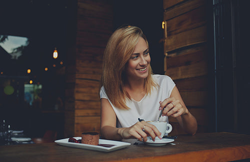 Young woman with beautiful smile looking away while sitting in cafe during coffee break happy charming hipster girl relaxing in modern cafe female enjoying good day during morning breakfast in bar