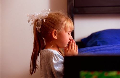 Young girl praying near bed,Young girl praying near bed,precious moments book of bedtime prayers
