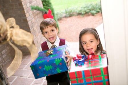 Two children hold Christmas presents, smiling at the viewer in the front doorway.,dreaming of a pink christmas gigi dvd