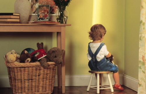 Young child sitting in corner as punishment,parenting book child discipline child behavior