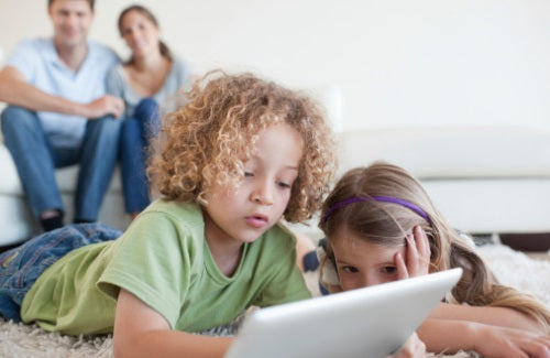 Young children using a tablet computer while their happy parents,Internet protect your kids online activity,Young children using a tablet computer while their happy parents