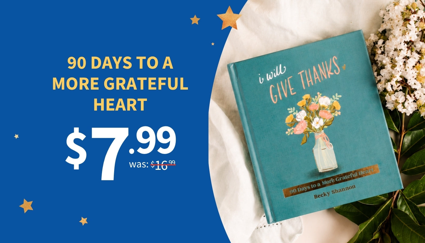 A teal hardcover book titled 'I Will Give Thanks' is displayed on white fabric next to white flowers, with a blue promotional background and text reading '90 DAYS TO A MORE GRATEFUL HEART $7.99 was: $16.
